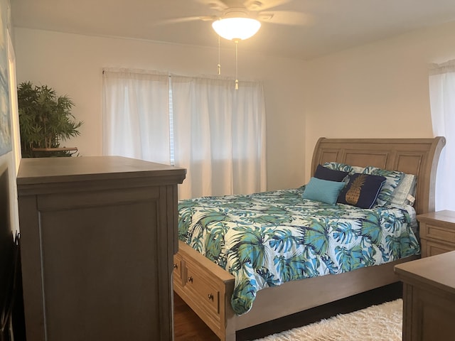 bedroom with dark hardwood / wood-style floors and ceiling fan