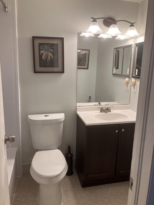 bathroom featuring tile patterned flooring, vanity, toilet, and a bathing tub