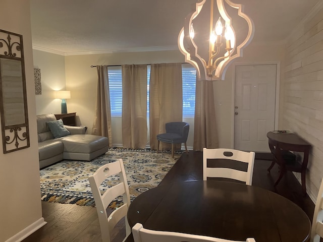 dining area featuring crown molding, wood-type flooring, and an inviting chandelier