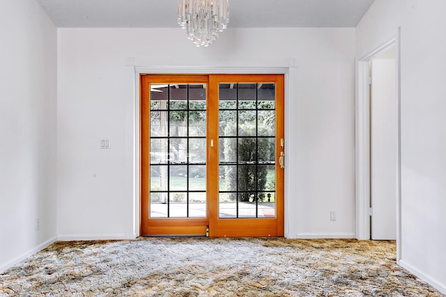 spare room with a chandelier and carpet flooring