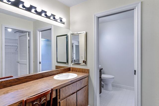 bathroom featuring vanity, toilet, and a shower with door