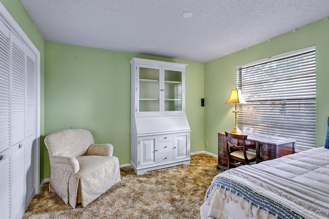 bedroom with carpet, a textured ceiling, and a closet