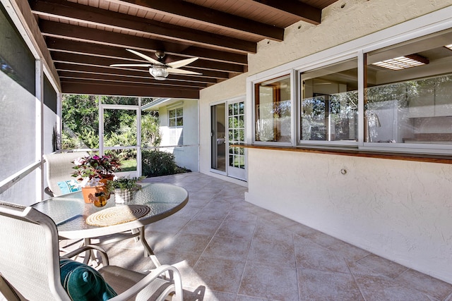 unfurnished sunroom with wood ceiling, ceiling fan, and beam ceiling