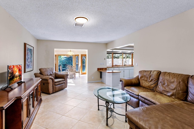 tiled living room with a textured ceiling and sink