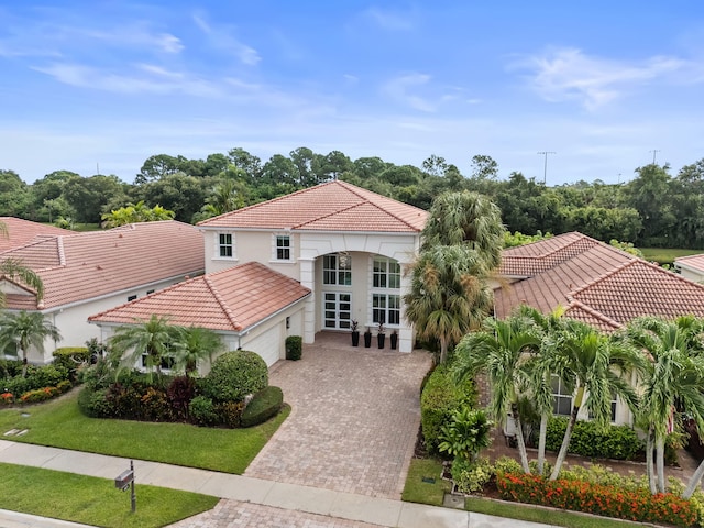 view of front of home featuring french doors, a front lawn, and a garage