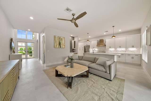 living room featuring french doors, ceiling fan, and sink