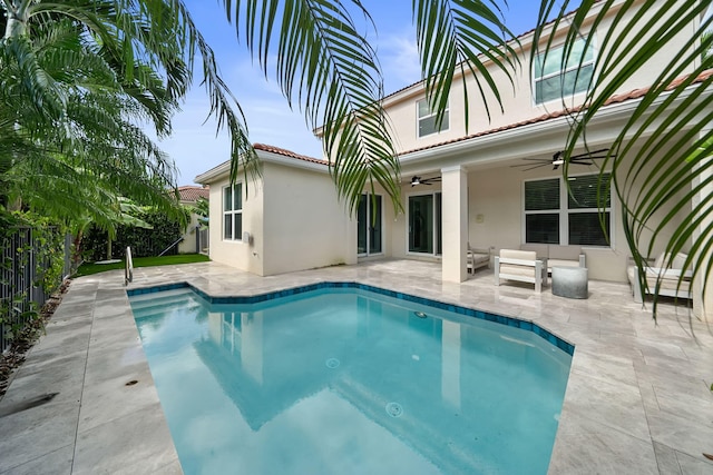 view of swimming pool featuring ceiling fan and a patio