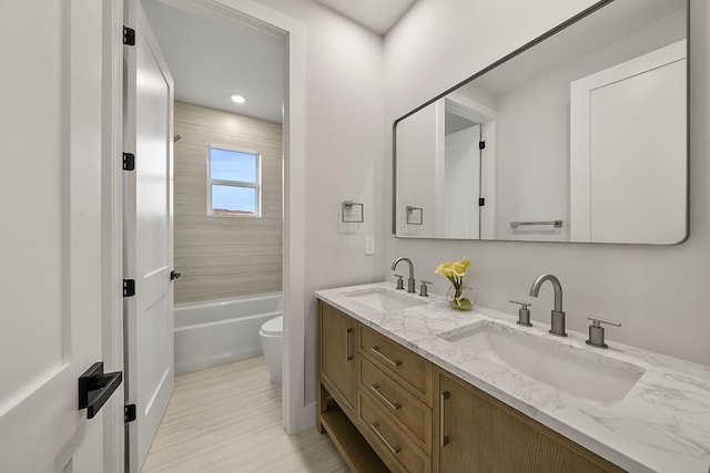 full bathroom with vanity, tiled shower / bath combo, and toilet