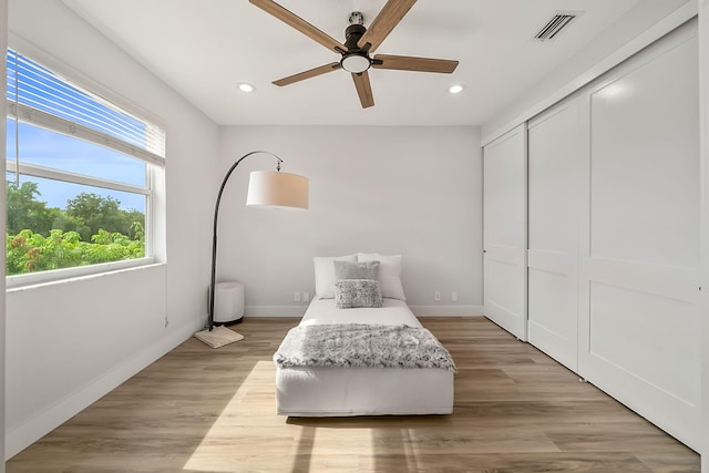 bedroom featuring ceiling fan, a closet, and light hardwood / wood-style flooring