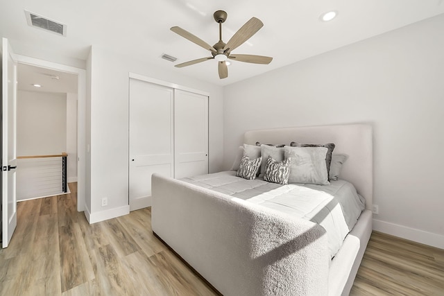 bedroom featuring ceiling fan, a closet, and light hardwood / wood-style floors