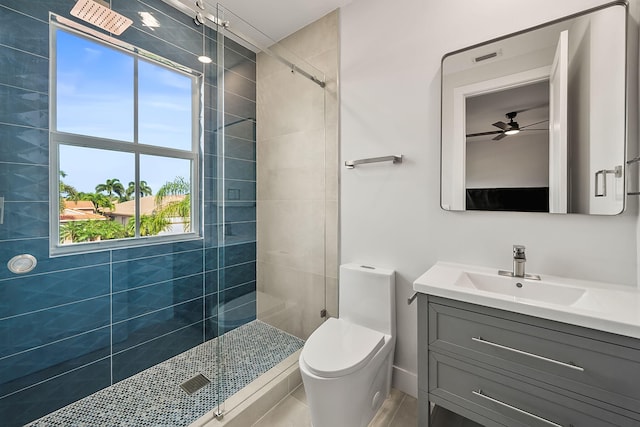 bathroom featuring vanity, a shower with door, toilet, and ceiling fan