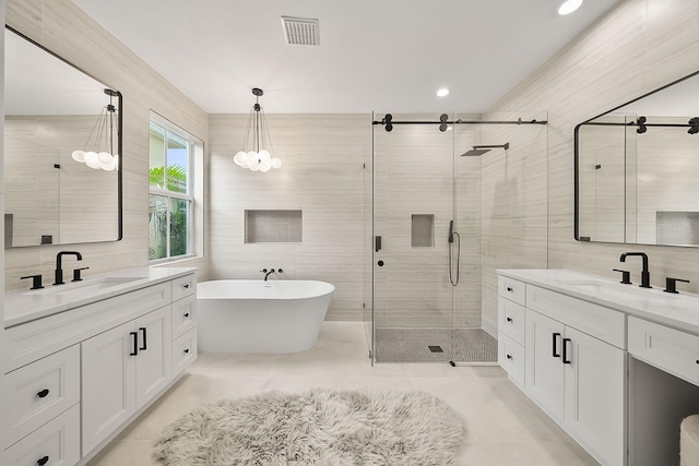 bathroom featuring tile patterned floors, vanity, tile walls, and plus walk in shower