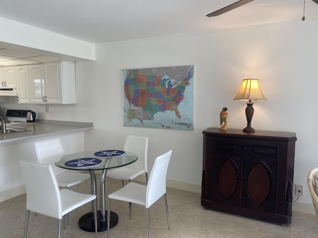 dining room with ceiling fan and sink