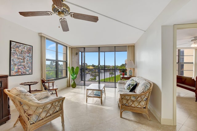 tiled living room with expansive windows, ceiling fan, and a water view