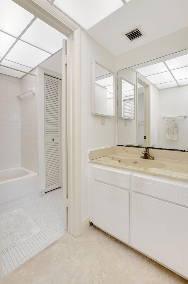 bathroom featuring tiled shower / bath, vanity, and tile patterned flooring