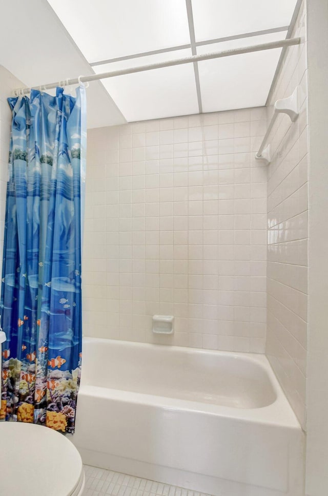 bathroom featuring tile patterned floors, shower / bath combination with curtain, and toilet