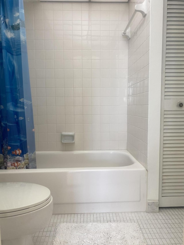 bathroom featuring toilet, shower / bath combination with curtain, and tile patterned floors