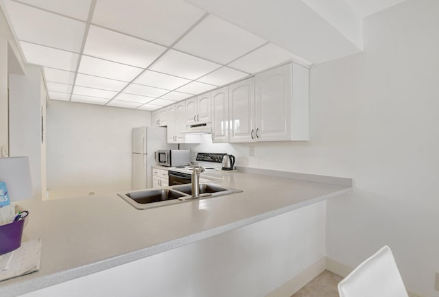 kitchen with range with electric stovetop, a paneled ceiling, sink, white cabinets, and white fridge