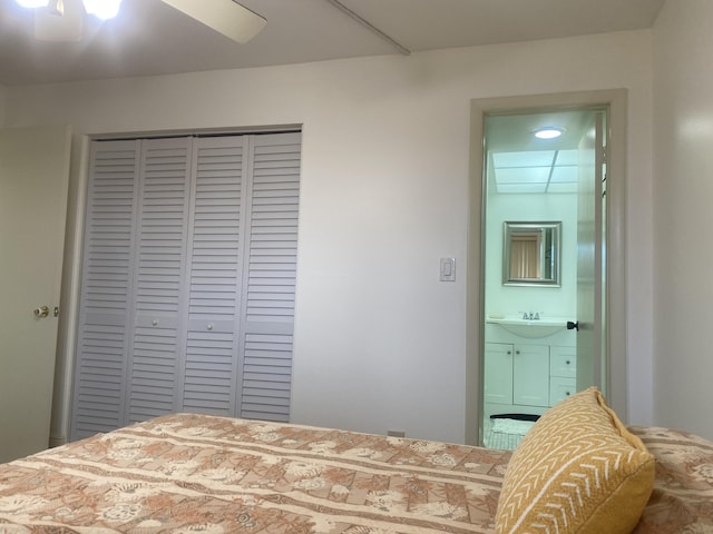 bedroom with a closet, ensuite bathroom, ceiling fan, and sink