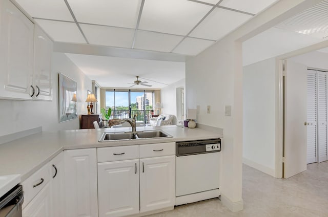 kitchen featuring a paneled ceiling, sink, white cabinets, white dishwasher, and kitchen peninsula