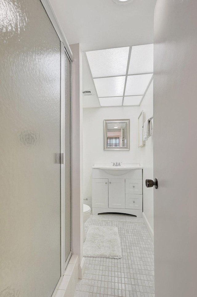 bathroom featuring walk in shower, tile patterned floors, vanity, and toilet