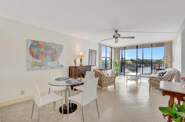 dining space with floor to ceiling windows, a water view, light tile patterned floors, and ceiling fan