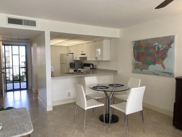 dining space featuring ceiling fan and sink