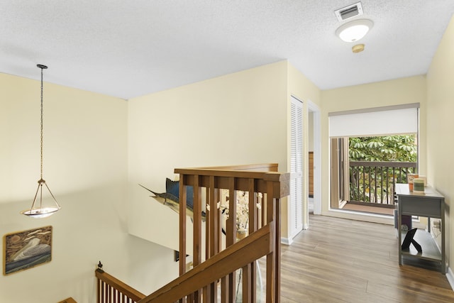 hall featuring a textured ceiling and hardwood / wood-style flooring