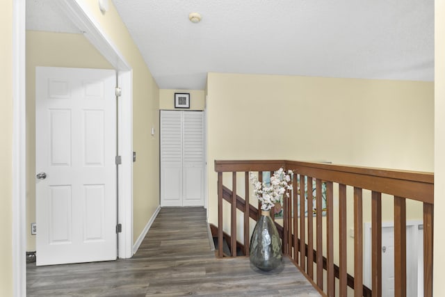 corridor featuring dark wood-type flooring and a textured ceiling