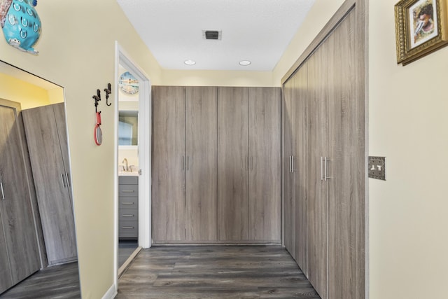 corridor with dark wood-type flooring and a textured ceiling