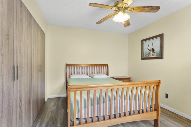 bedroom with hardwood / wood-style floors, a textured ceiling, and ceiling fan