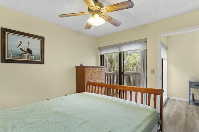 bedroom with a textured ceiling, ceiling fan, access to exterior, and light wood-type flooring