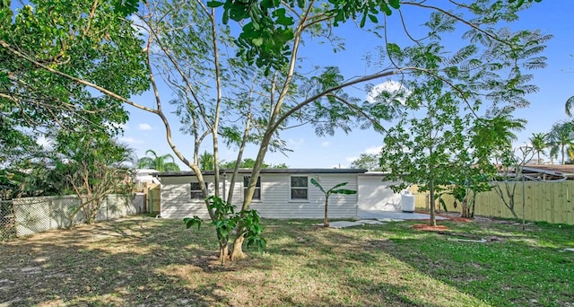 rear view of house with a lawn and a patio