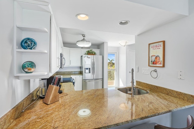 kitchen with kitchen peninsula, white cabinetry, sink, and appliances with stainless steel finishes