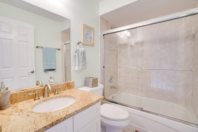 full bathroom with vanity, bath / shower combo with glass door, and toilet