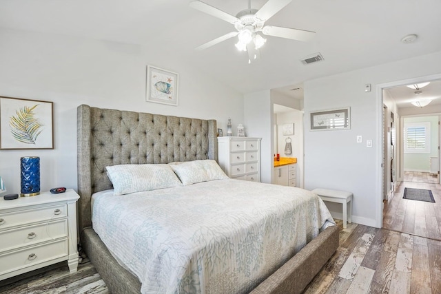 bedroom featuring ceiling fan, dark hardwood / wood-style flooring, lofted ceiling, and ensuite bath