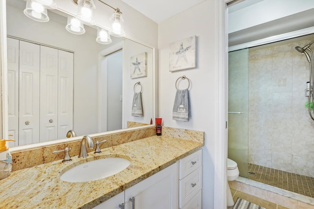 bathroom with tile patterned floors, vanity, toilet, and an enclosed shower