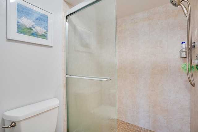 bathroom with toilet and a shower with shower door