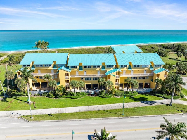 drone / aerial view featuring a water view and a beach view