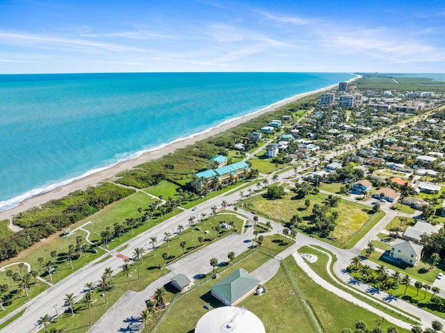 birds eye view of property featuring a water view and a beach view