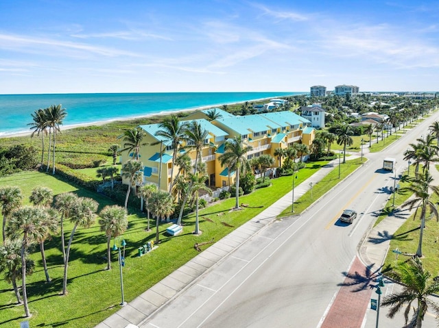 drone / aerial view with a water view and a beach view