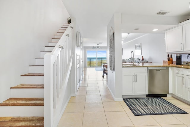 kitchen featuring white cabinets, dishwasher, light tile patterned floors, and sink