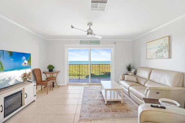 tiled living room featuring ceiling fan, a water view, and ornamental molding