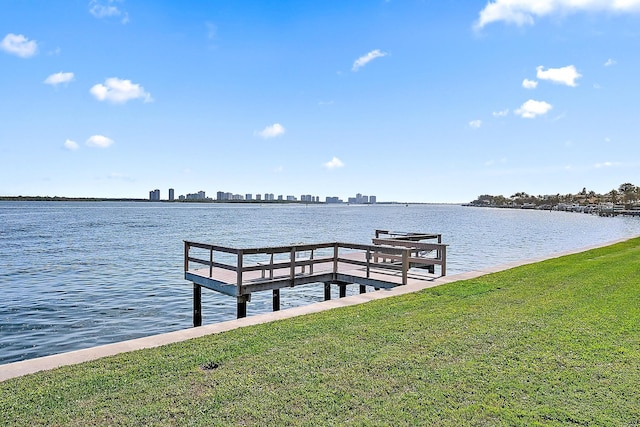 dock area featuring a lawn and a water view