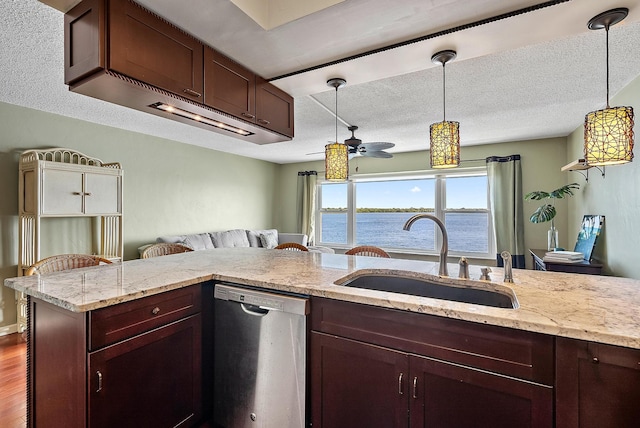 kitchen featuring ceiling fan, dishwasher, sink, pendant lighting, and a water view