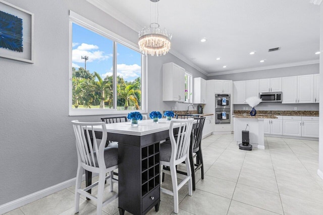 dining room featuring sink, light tile patterned flooring, a chandelier, and ornamental molding