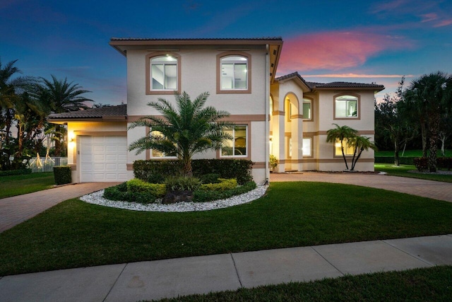 mediterranean / spanish house featuring a yard and a garage