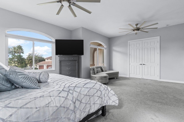 carpeted bedroom featuring ceiling fan and a closet