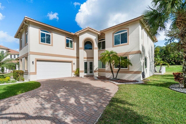 mediterranean / spanish-style house featuring a front lawn, a garage, and french doors