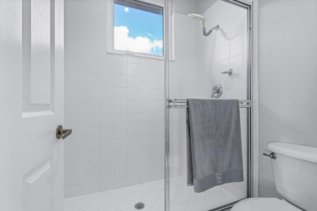 bathroom with toilet and an enclosed shower